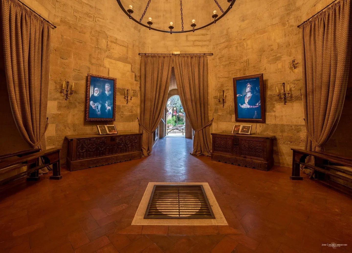 Pasillo abovedado del castillo de Almodóvar con dos retratos animados en las paredes